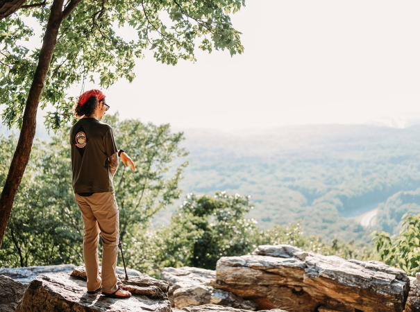 A man looking out over a rock